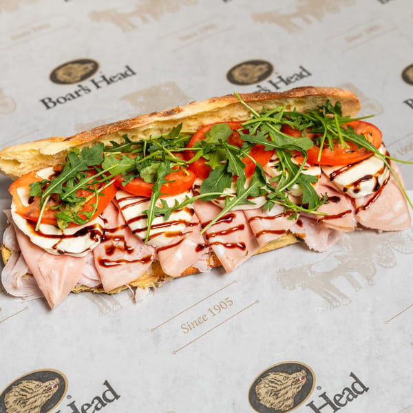 Boar's Head sandwich with mortadella, mozzarella, tomatoes, arugula, and balsamic glaze on a baguette.